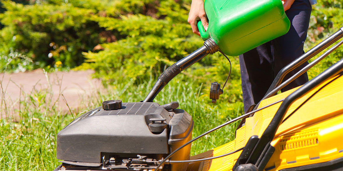 a petrol mower being filled with petrol