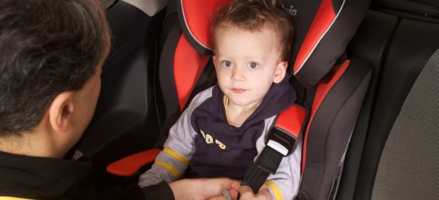 Adjusting the car seat straps around a toddler