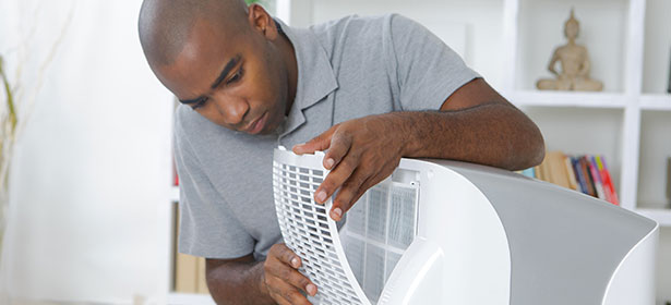Man removing filter from air conditioner
