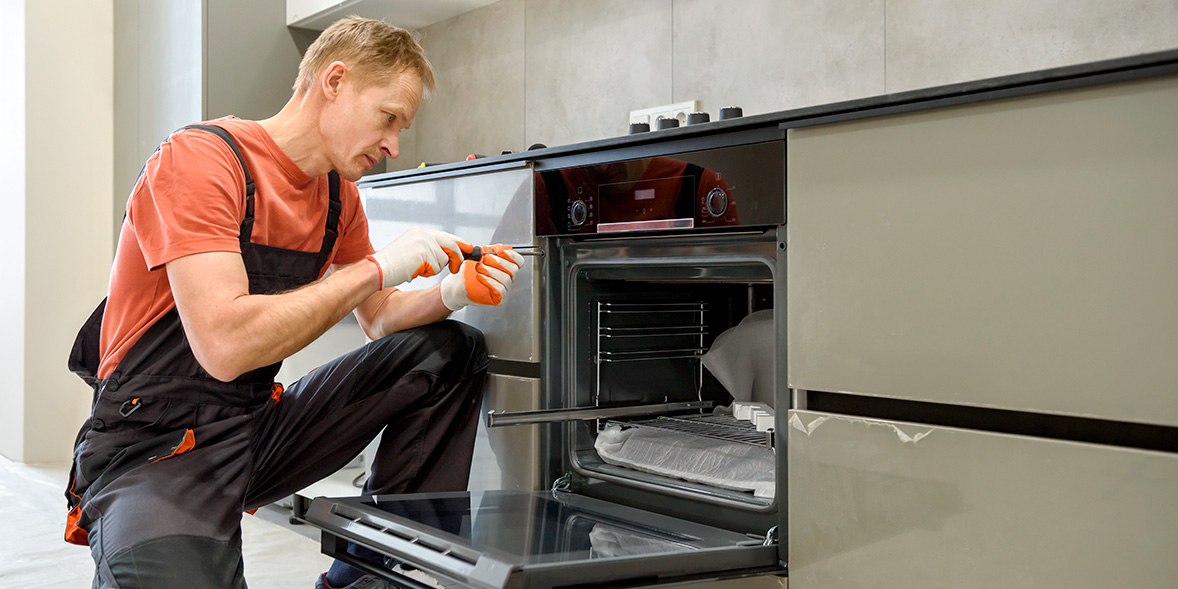 Repair technician working on a built-in oven